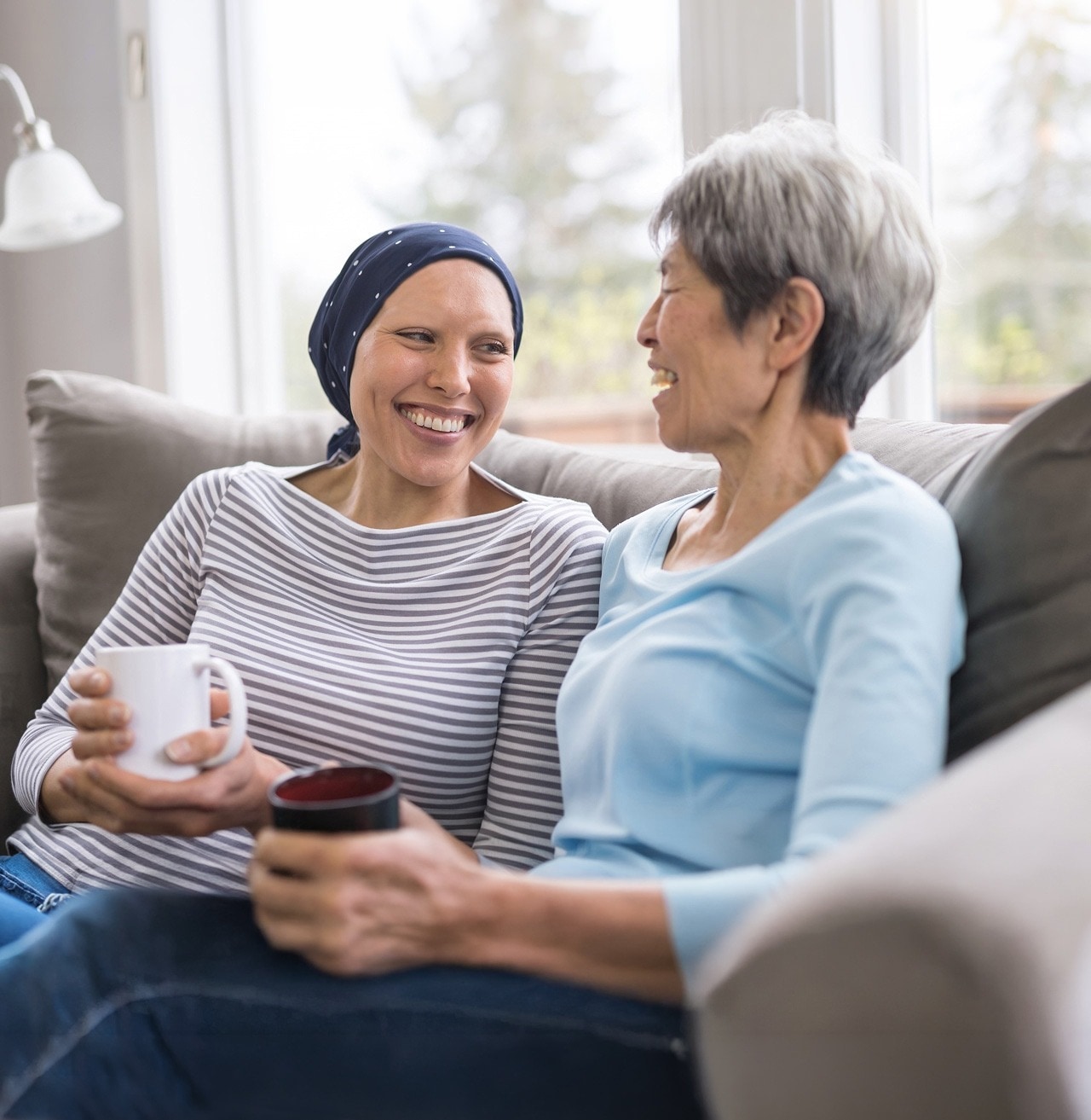 A lady battling cancer smiles with her supportive friend.