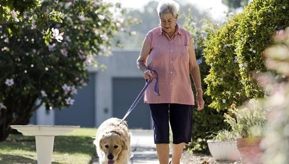 A woman walking her dog and exercising for healthy bones