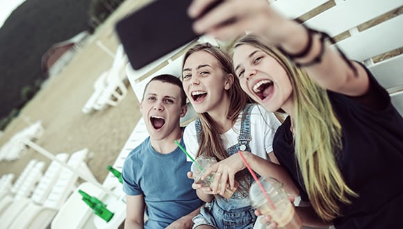 Three teenagers taking a selfie with their mouths open