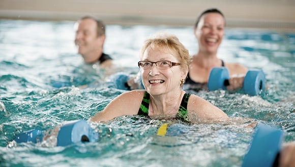 An elderly woman floating inside of a pool