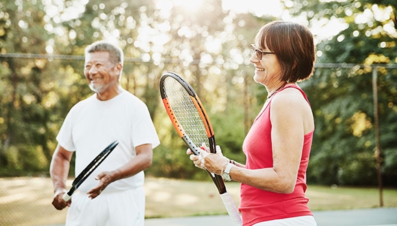 Older couple playing tennis 