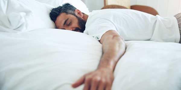 Man sleeping on a white bed