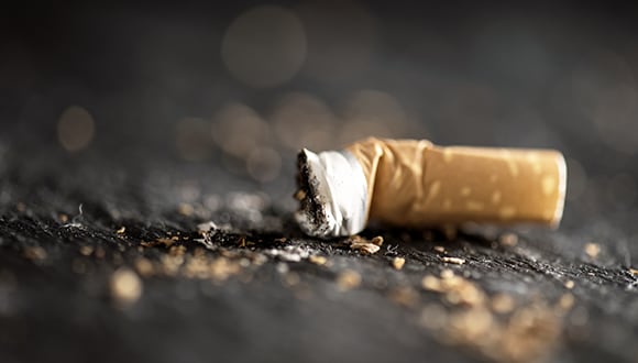 Photo of a used cigarette butt on the ground