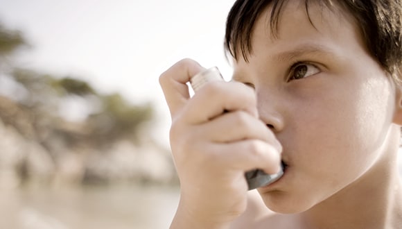 Young boy using an inhaler