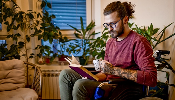 Man drinking a tea and reading, getting ready to fall asleep fast