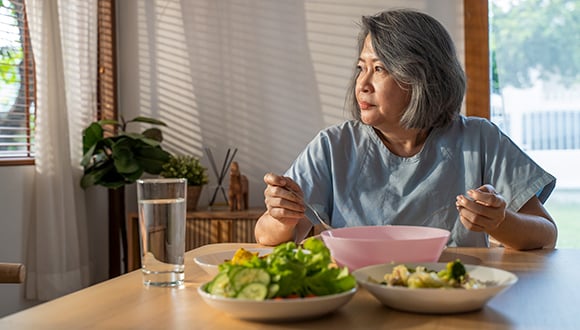 woman eating salad at a table