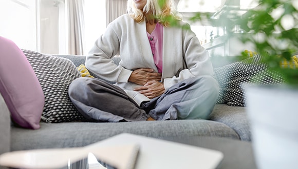 woman with IBS clutching her stomach