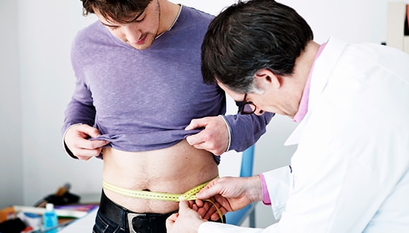 Man getting his BMI checked with a doctor