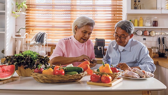 Man and woman sitting in kitchen with healthy food