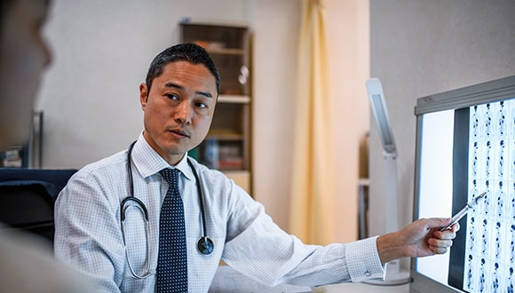 physician pointing to an x-ray image