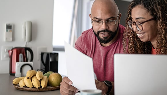 Couple looking at their finances to save money this eofy