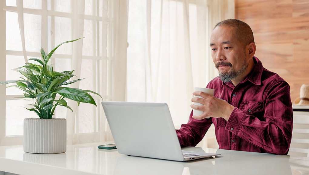 Man sitting at a laptop looking into a mental health treatment plan