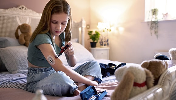 a young girl with diabetes checking her sugar levels