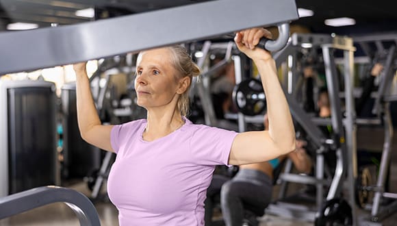 Lady doing exercises for lower back pain at a gym