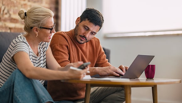 a couple using a laptop, signing up for health insurance