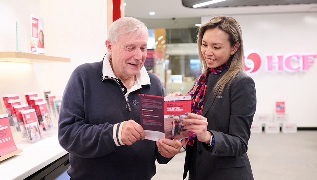 HCF staff assisting an older man with his private health insurance 