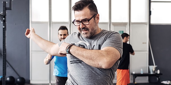 A man doing exercise with other people in the background