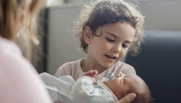 Little girl with new sibling preparing to bring baby home