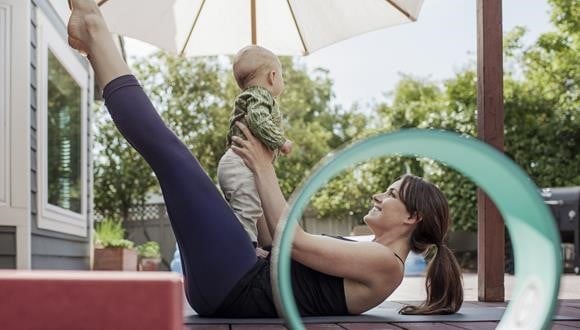 Mum holding baby while exercising after birth