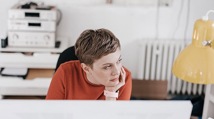 Woman in front of her computer, distracted