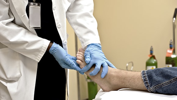 doctor checking the feet of a patient