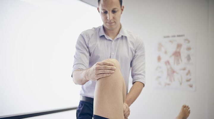 Chiropractor adjusting patient's knee