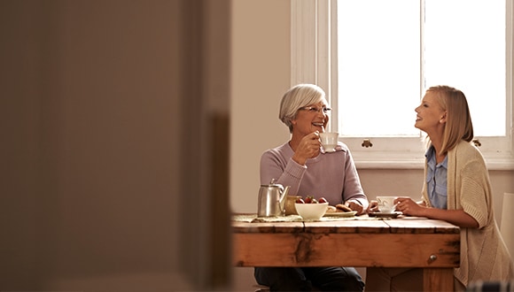 Two middle aged women chatting and having tea