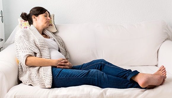 Pregnant woman lounging on a couch