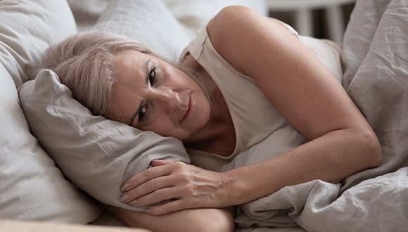 Woman with restless legs in bed
