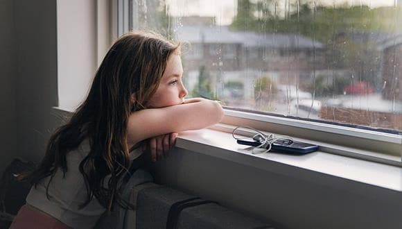 Child looking out the window after having a talk about eating disorders