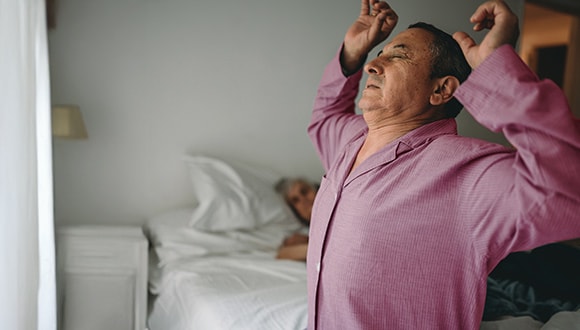 man in pyjamas waking up from his sleep
