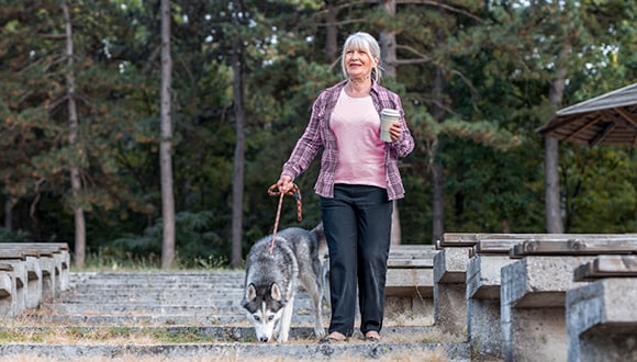 Lady walking a dog to maintain a healthy weight