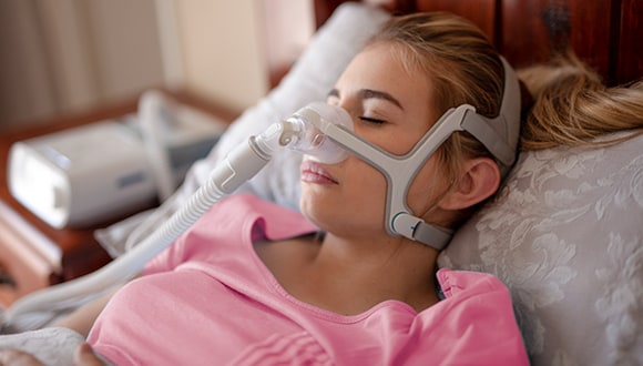 Woman sleeping with CPAP machine