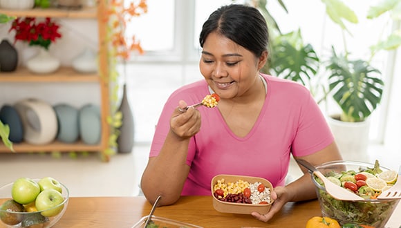 Lady eating a healthy lunch at the dinner table
