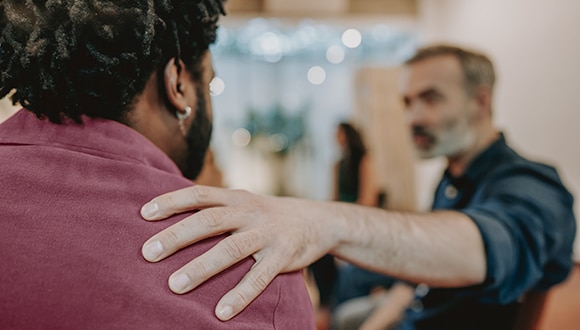 Man confronting another male experiencing mental health issues