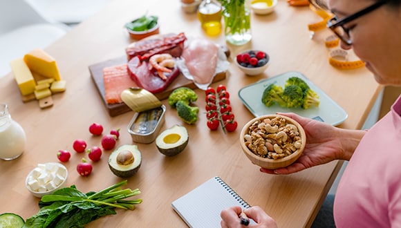 Woman noting down her food intake on a notepad