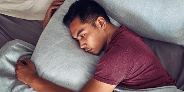 Man laying in bed trying to sleep