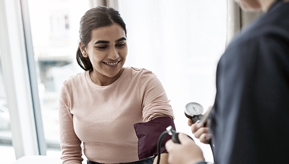 Young woman getting her blood pressure checked by a nurse
