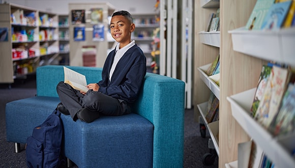 Young student sitting in the library as part of The Smith Family program