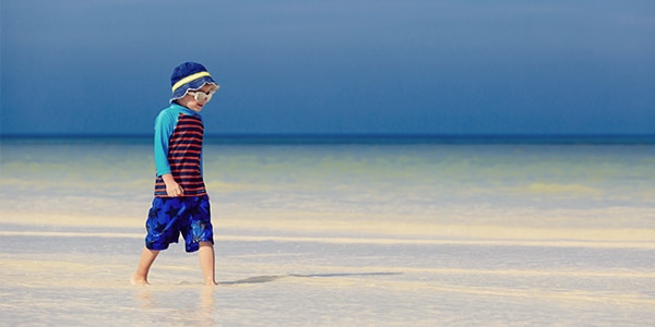 Young boy walking on the beach 