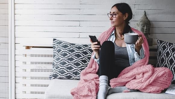 Woman relaxing at home reading about endometriosis