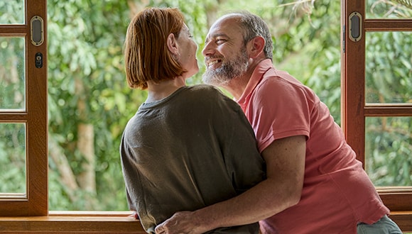 A woman and a man embracing and smiling