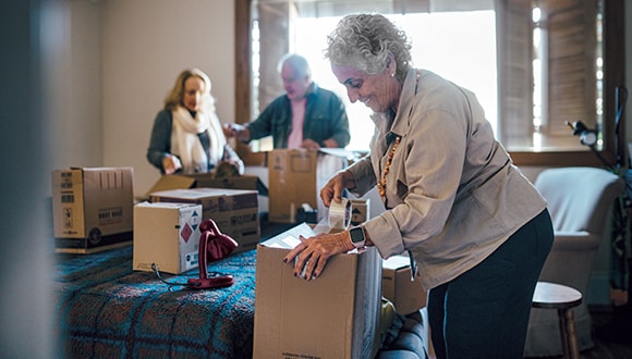 older woman unpacking boxes in her new house