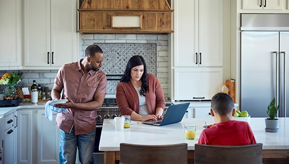 Family looking at finances in dining room 