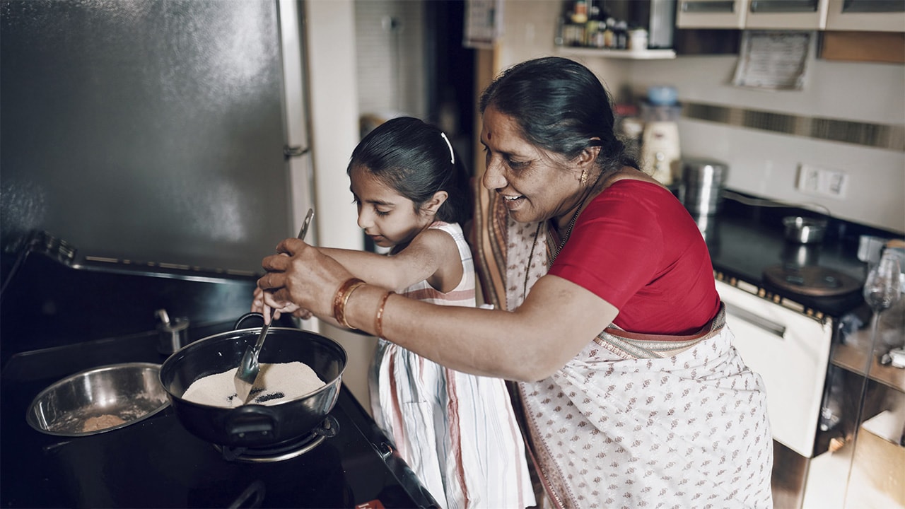 International visitors on holiday, cooking in the kitchen.