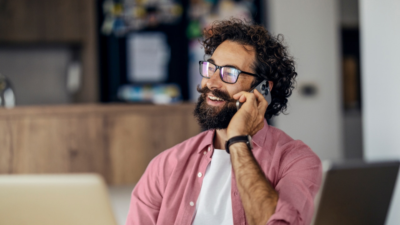 Man smiling while on the phone.