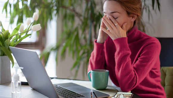 A woman struggling with insomnia sitting at a laptop