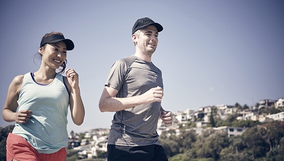 A photo of two people jogging (Female to the left and Male on the right)