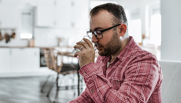 Man drinking in his kitchen