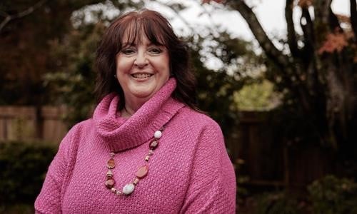 Woman smiling in pink jumper
